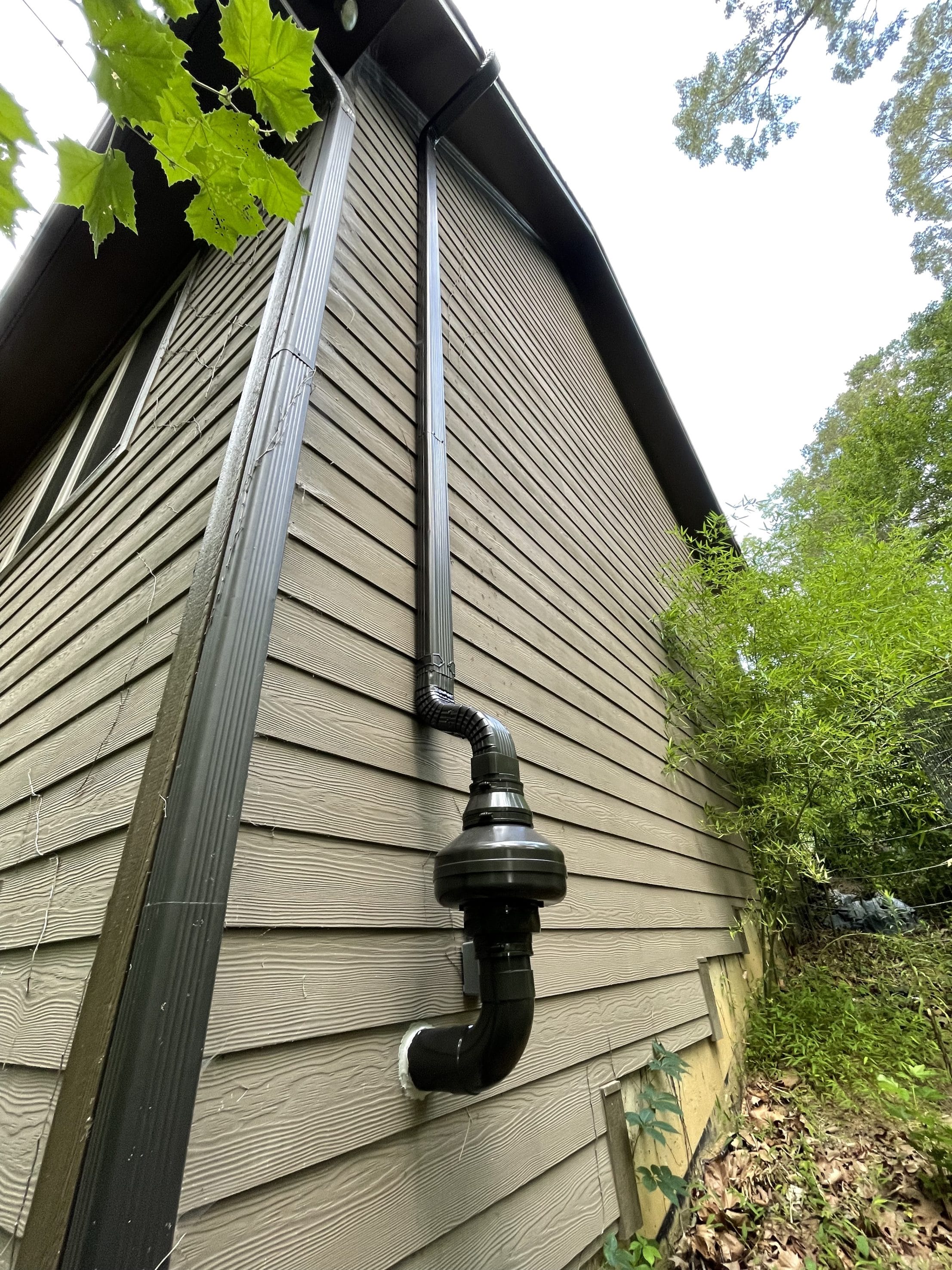 Radon mitigation system installed on house exterior
