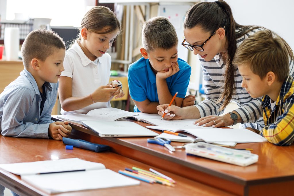 Stock image of a school teacher educating school students.
